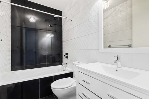 A white bathroom with a toilet, sink, and bathtub.
