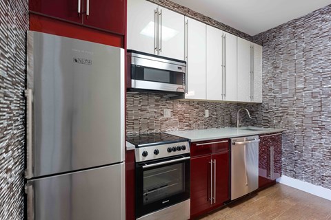 A kitchen with a stainless steel refrigerator, oven, and microwave.