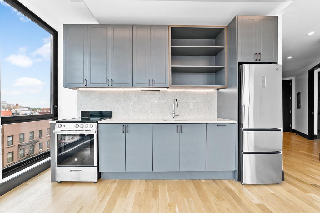 A kitchen with a view of the city outside the window.