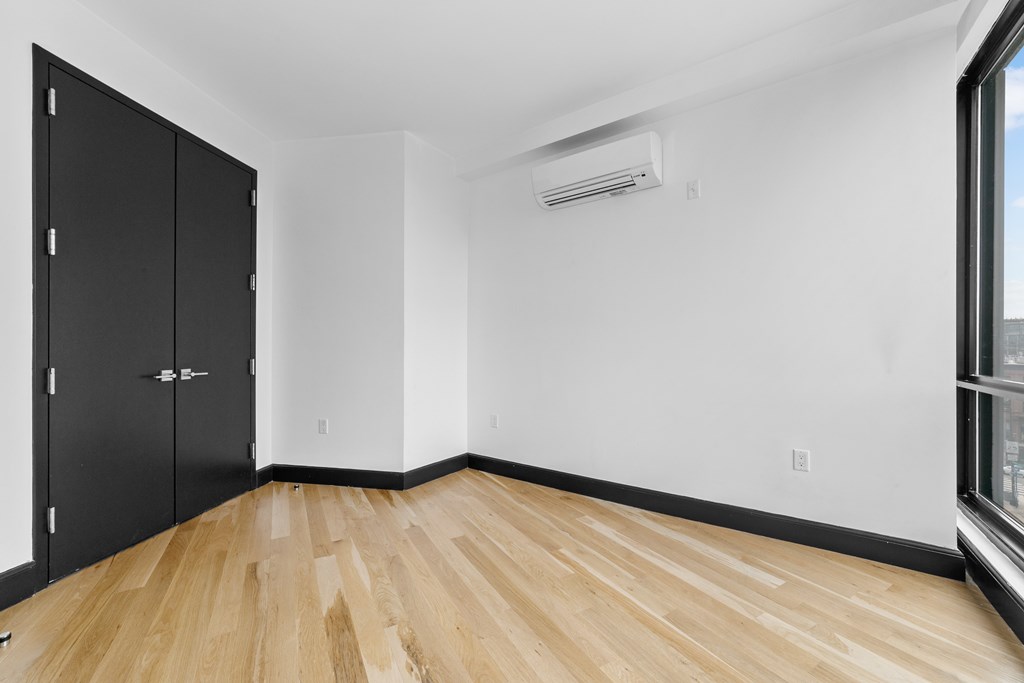 A room with black cabinets and wooden flooring.
