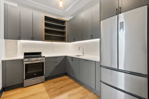 A modern kitchen with a stainless steel refrigerator and a built-in oven.