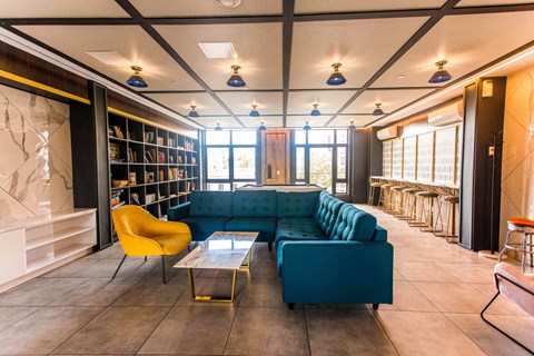 A living room with a blue couch and a yellow chair.