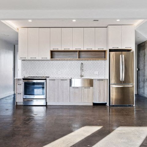 A modern kitchen with a stainless steel refrigerator and wooden cabinets.