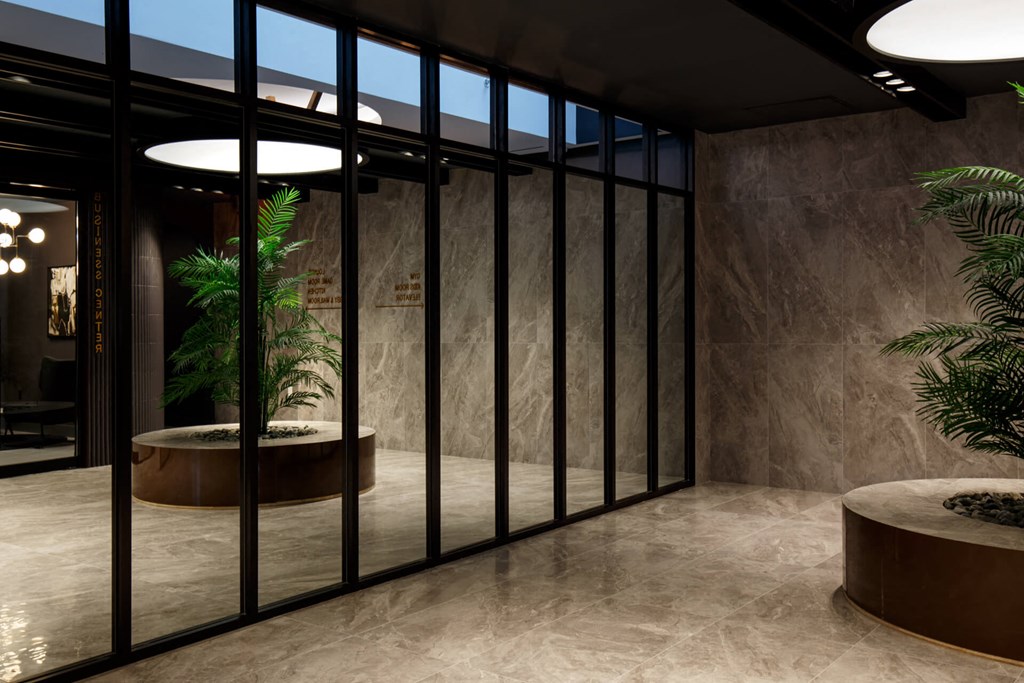 a lobby with glass doors and a potted plant