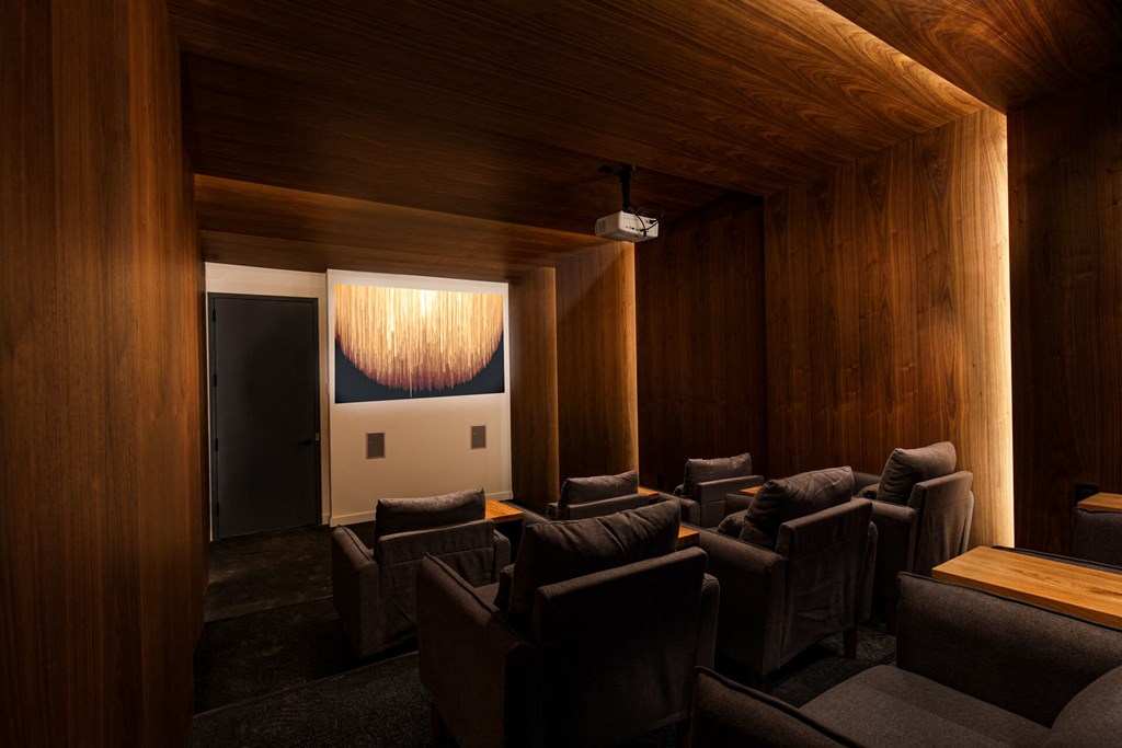 a large screening room with leather chairs and a projector screen