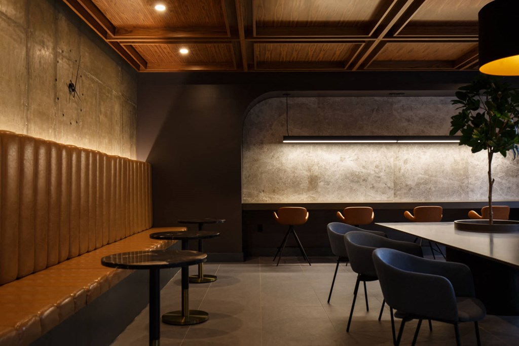 a restaurant with a long table and chairs and a wooden ceiling