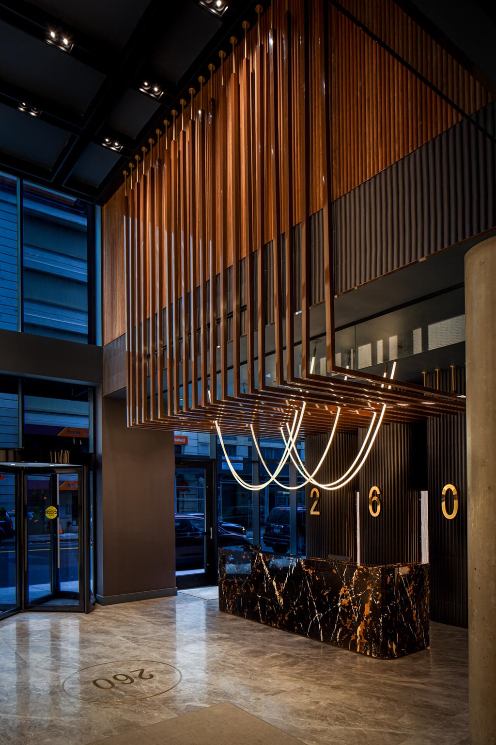the lobby of the building has a marble reception desk and a large number of lights