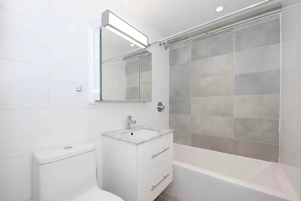 A white bathroom with a toilet, sink, and bathtub.