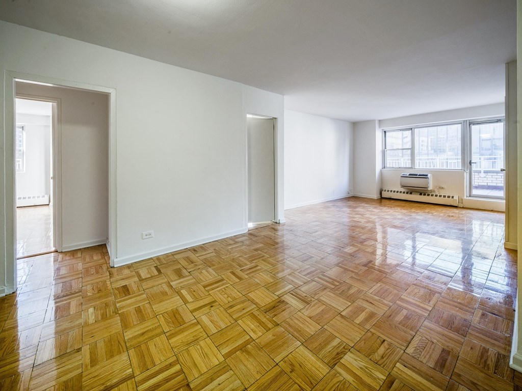 A room with wooden flooring and white walls.