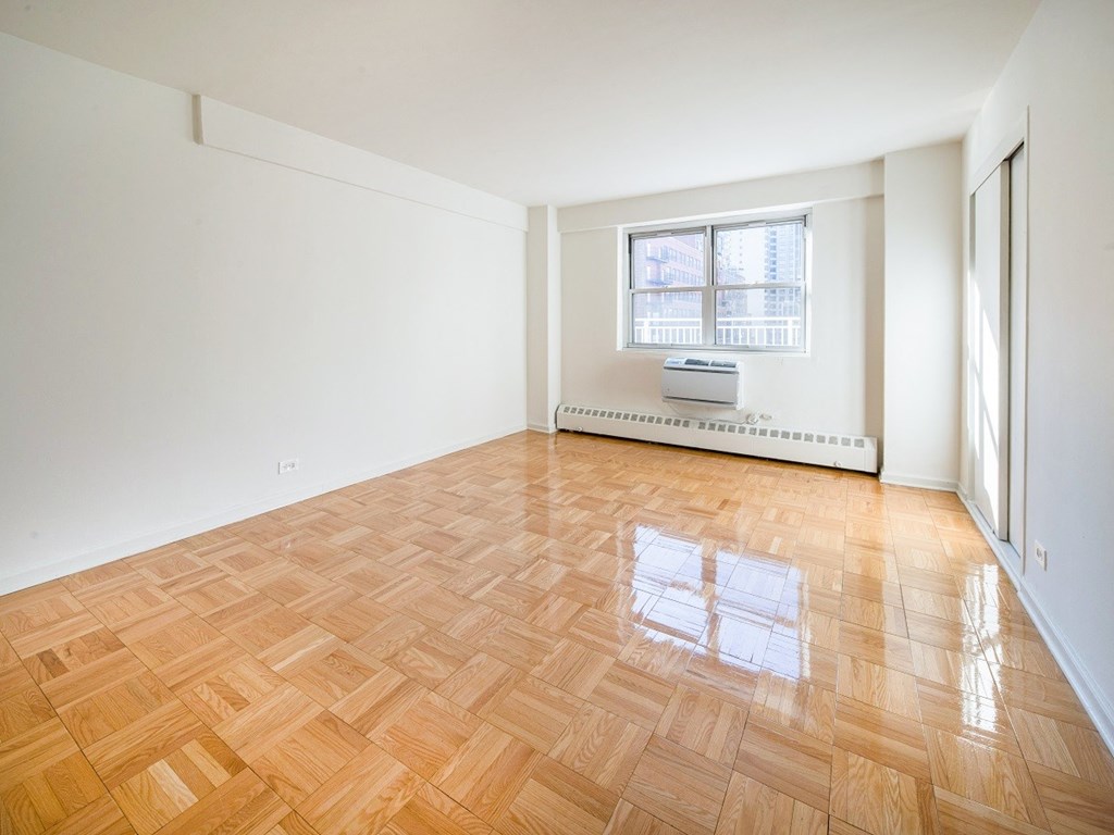 A room with a window and a radiator on the wall.