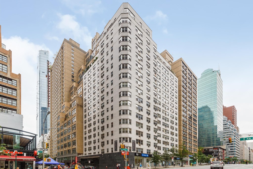A tall building with a lot of windows in the middle of a city street.