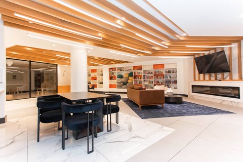 Community lounge with fireplace and library shelves at 1134 Fulton Street Apartments, Brooklyn, NY