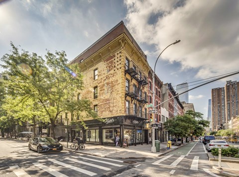 a city street with a brick building and a crosswalk