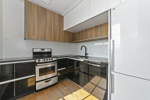 A modern kitchen with a stove, oven, and refrigerator.