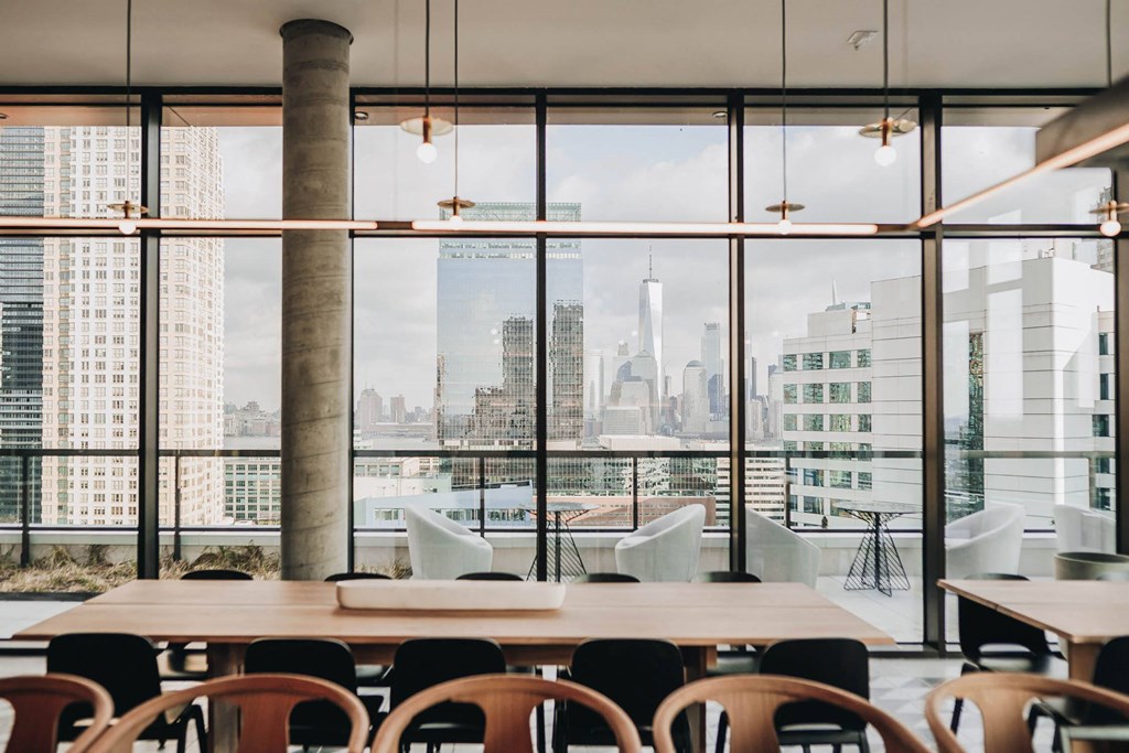 a view of the city from a restaurant with a table and chairs at The Lively, Jersey City New Jersey