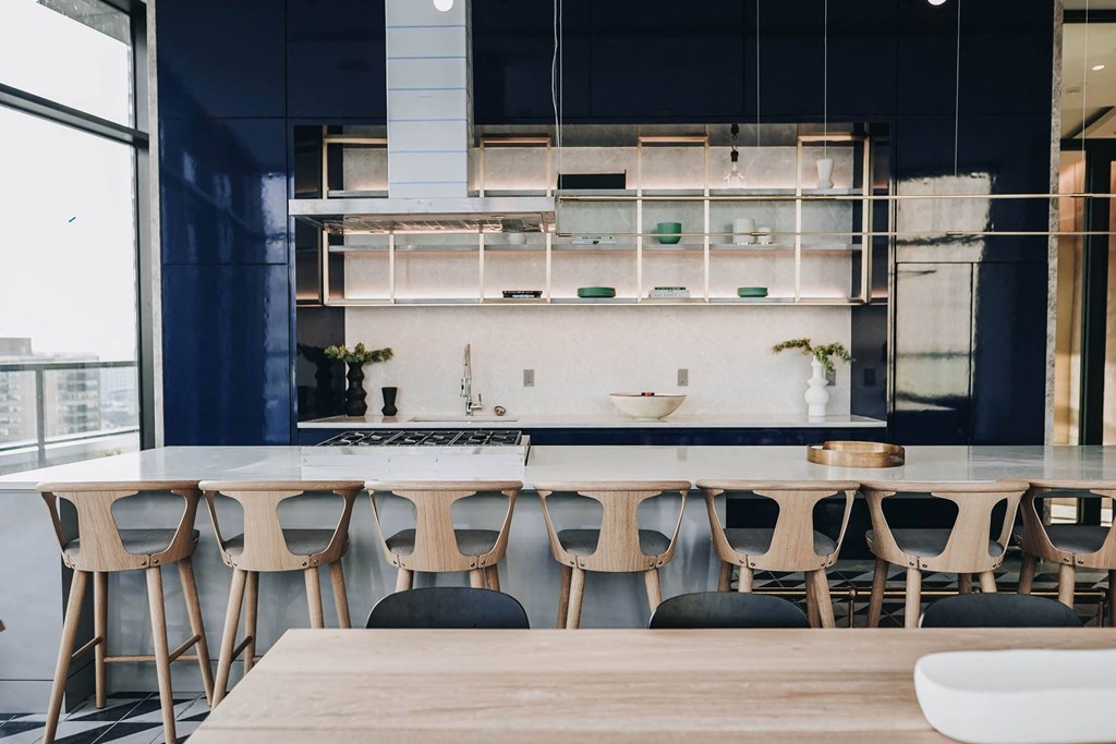 a large kitchen with a long table and chairs in front of a window at The Lively, Jersey City