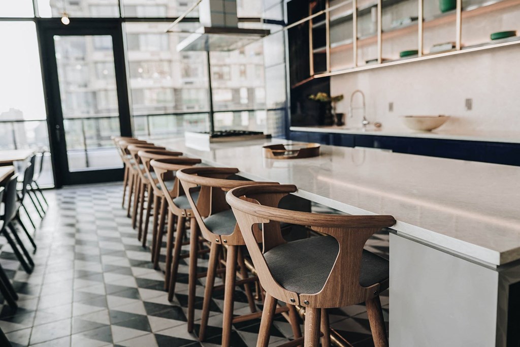 a row of bar stools in a restaurant with a white counter top and a at The Lively, New Jersey