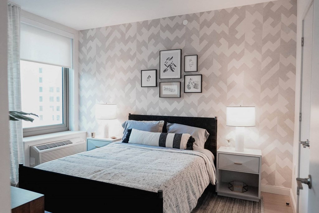 a bedroom with a bed and pictures on the wall at The Lively, Jersey City