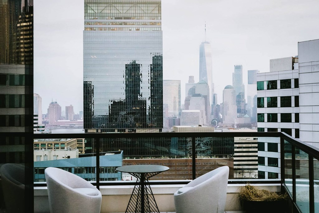 a view of the city skyline from a restaurant with a glass window at The Lively, Jersey City, NJ 07302