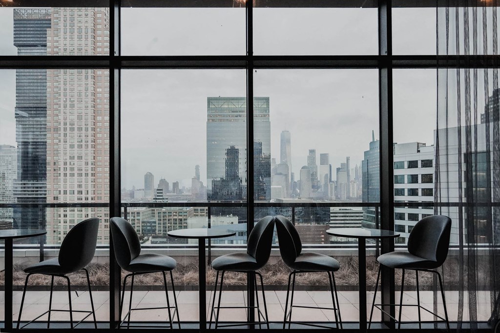 a view of the city skyline from a restaurant with tables and chairs at The Lively, Jersey City, NJ 07302