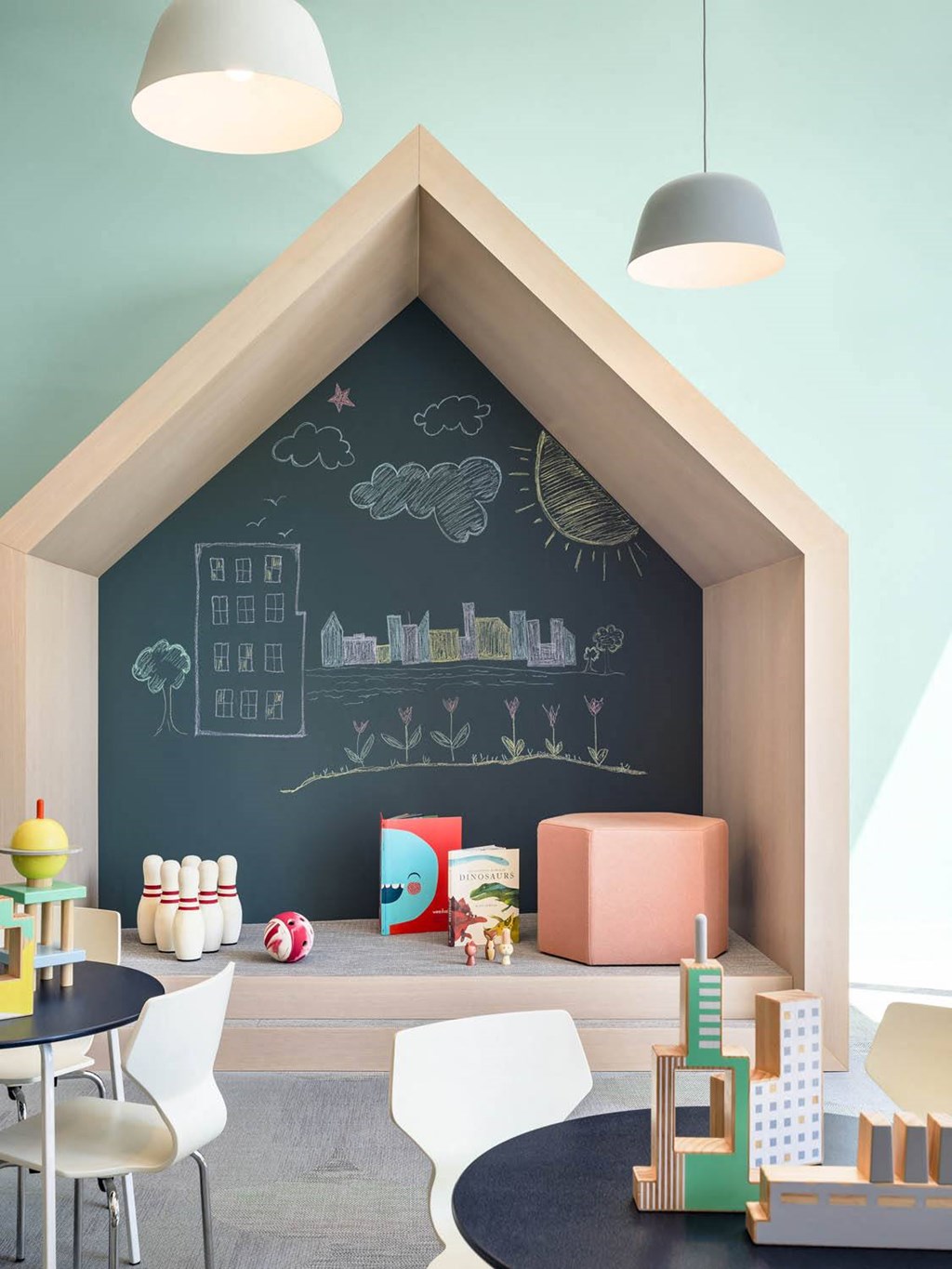 a childs playroom with a chalkboard wall and a table and chairs at The Lively, Jersey City, NJ 07302