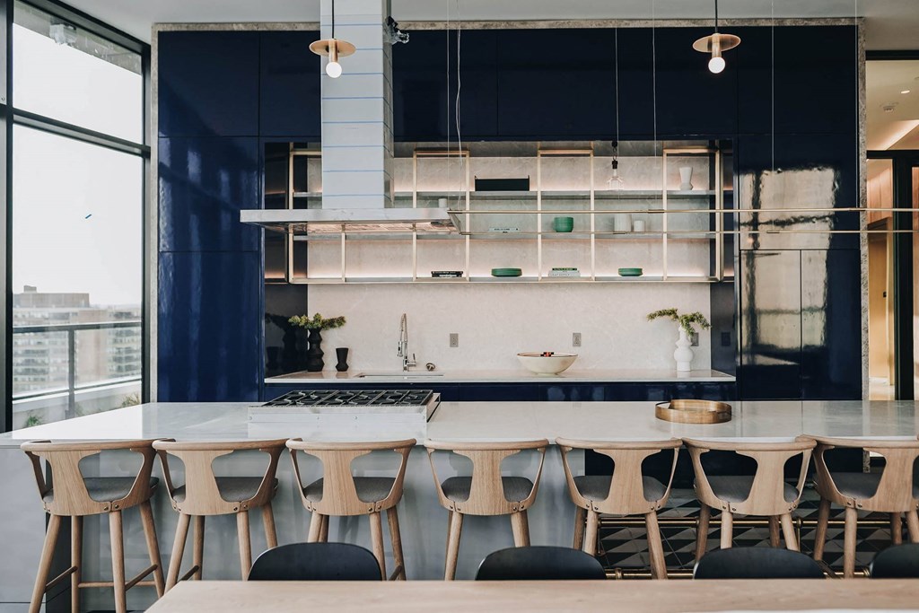 a kitchen with a long table and chairs in front of a kitchen counter at The Lively, Jersey City, NJ