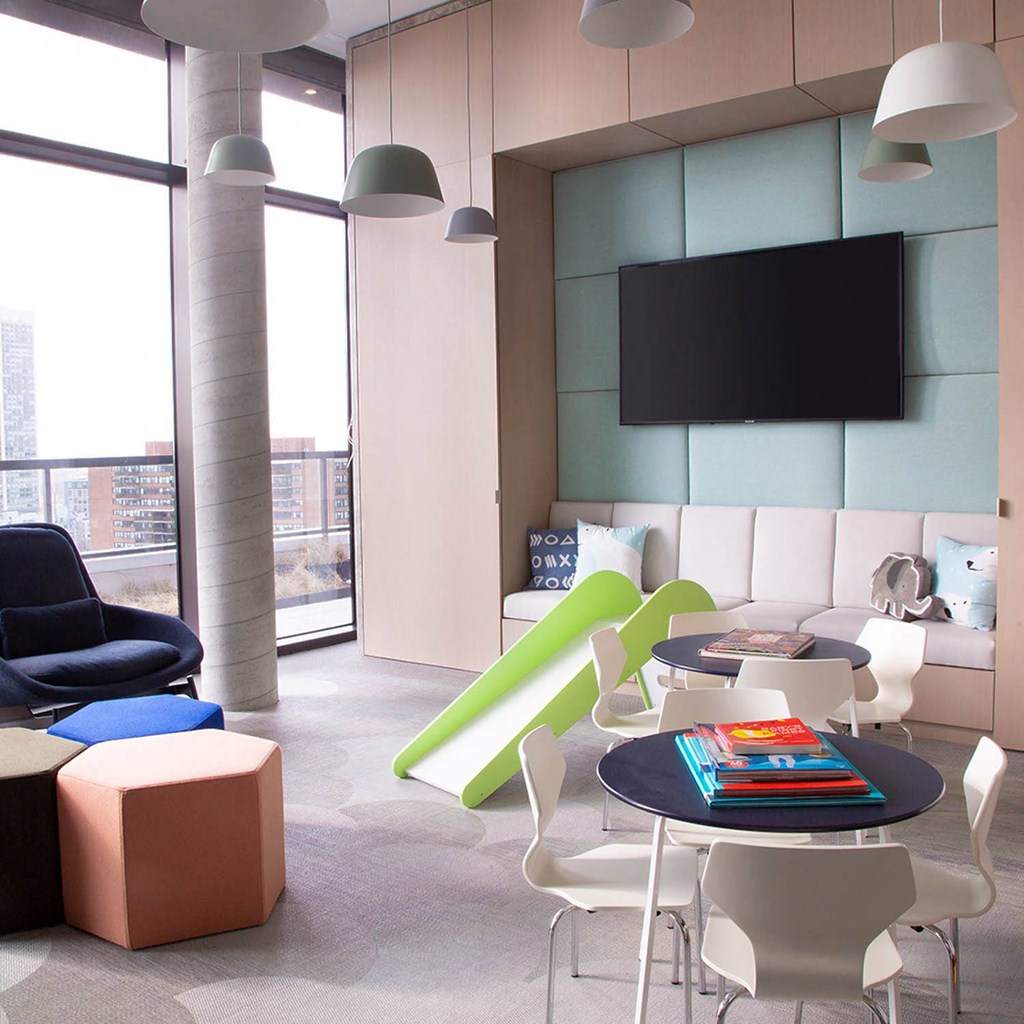 a living room with a table and chairs and a television at The Lively, Jersey City, NJ 07302