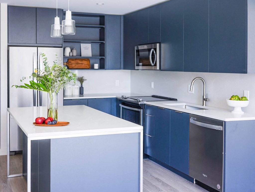 a kitchen with white counters and blue cabinets and a sink at The Lively, New Jersey