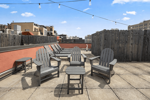 A patio with grey furniture and a wooden fence.
