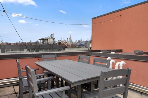 A table and chairs are set up on a rooftop patio.