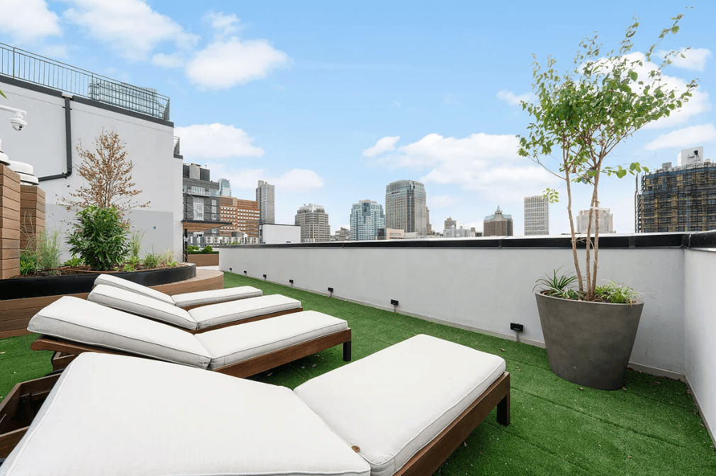 a roof terrace with lounge chairs and a view of the city