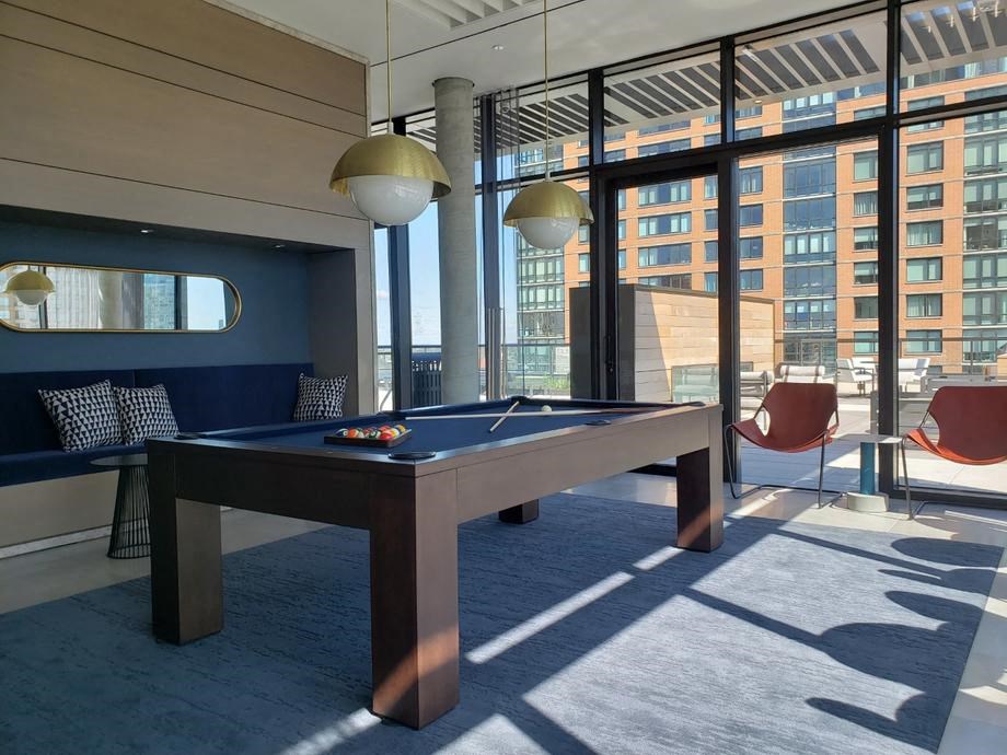 a pool table in a room with large windows at The Lively, Jersey City
