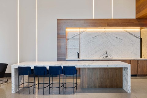 a kitchen with a marble counter top and blue chairs