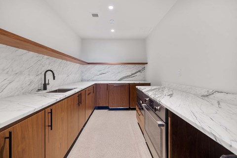 the kitchen has marble counter tops and wooden cabinets and stainless steel appliances