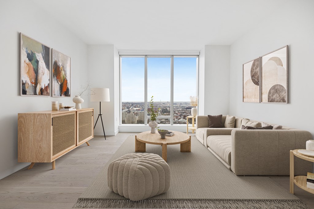 a living room with a couch and a table and a window at The Paxton, New york