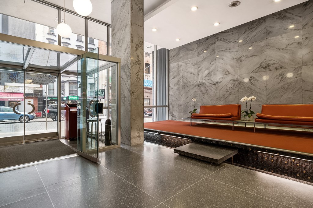 A glass door with a red trash can in front of it.