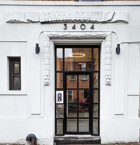 The entrance to a building with a glass door and a sign above it that reads "Graham Court 3404".