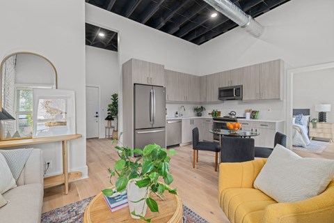 A living room with a yellow couch and a coffee table with a plant on it.