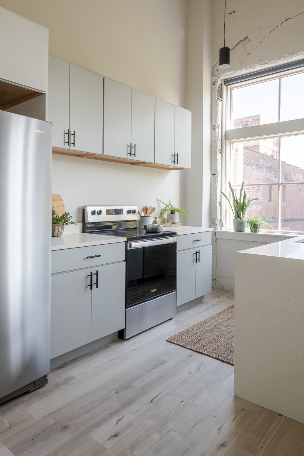 a kitchen with white cabinets and a wood floor at The 22 Apartments, St. Louis, 63103