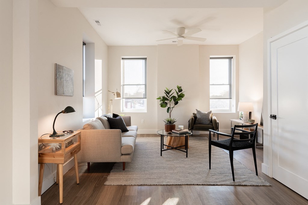 a living room with a couch and a table and a ceiling fan