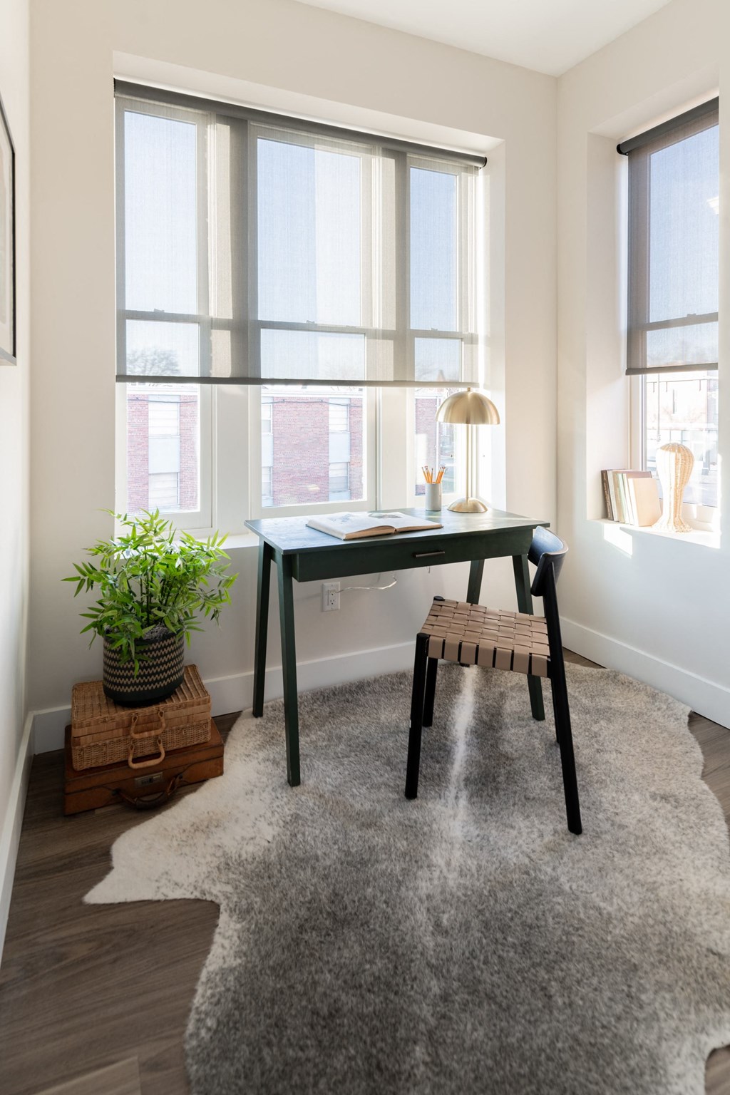 a home office with a desk and a chair in front of a window
