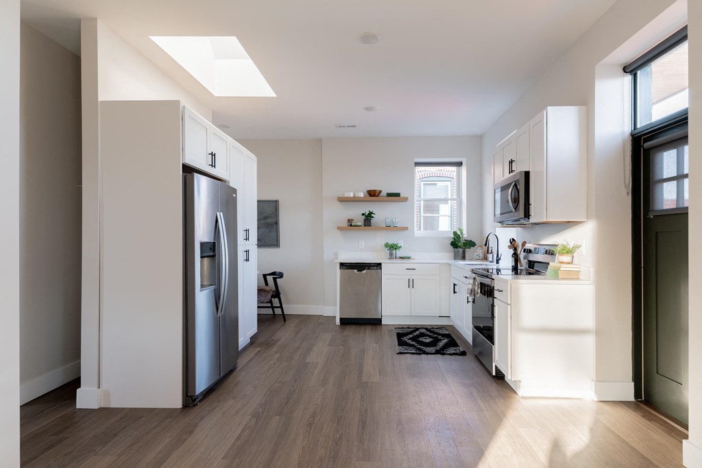 a kitchen with white cabinets and a stainless steel refrigerator