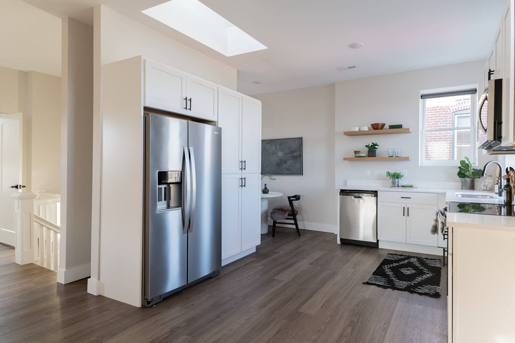 a kitchen with white cabinets and a stainless steel refrigerator