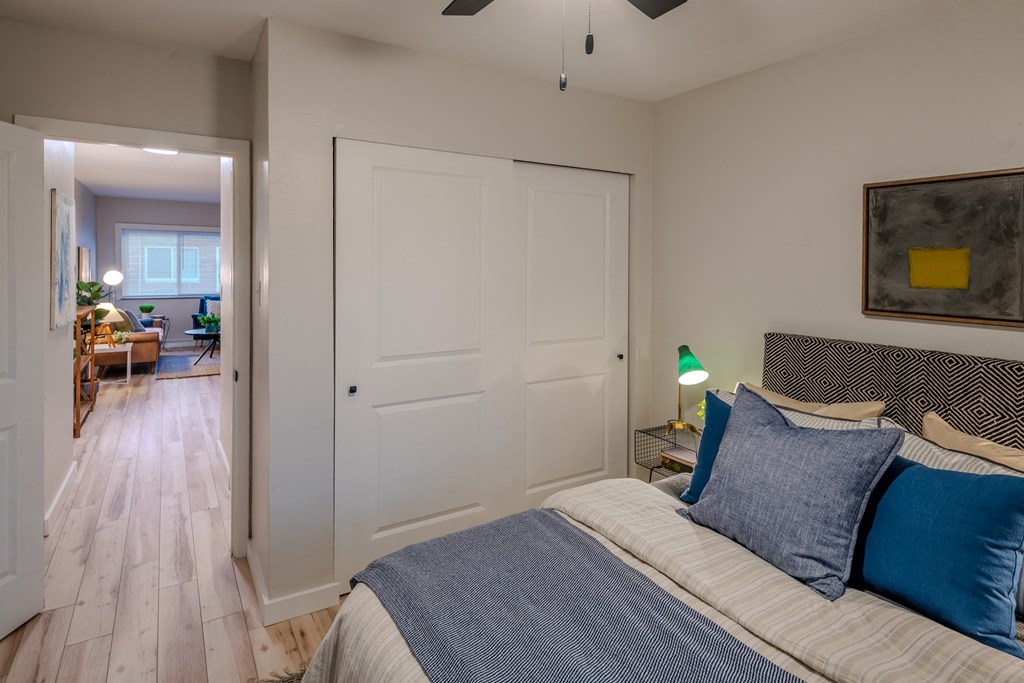 a bedroom with a bed and a door to a living room