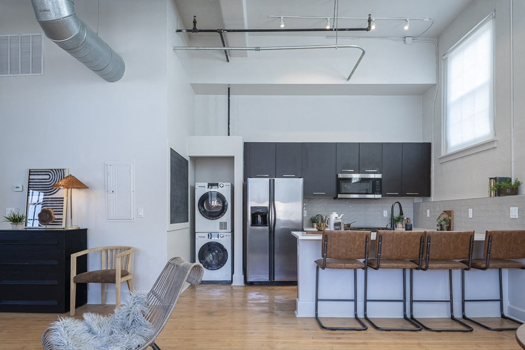a kitchen and living room with a washing machine and a washer and dryer