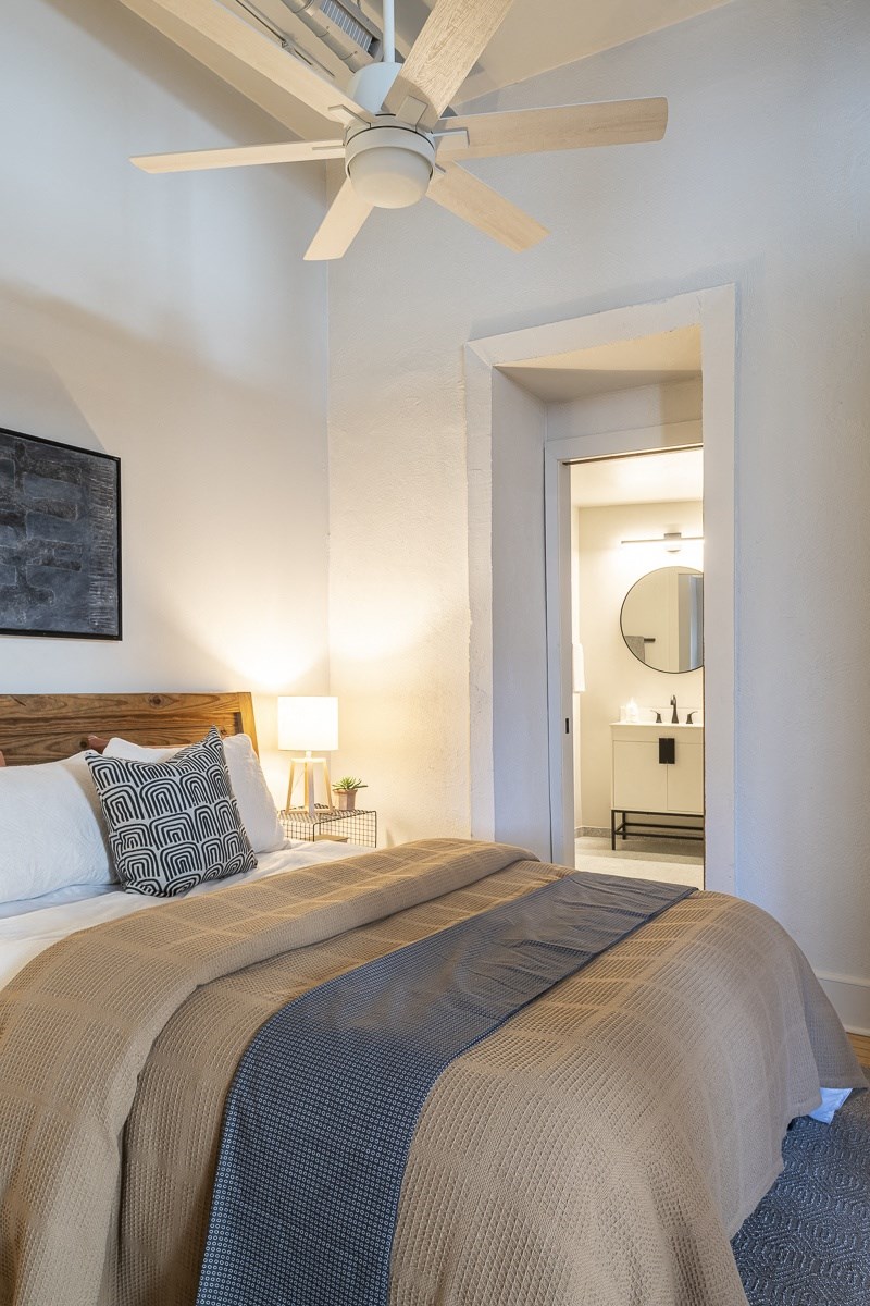 a bedroom with a bed and a ceiling fan