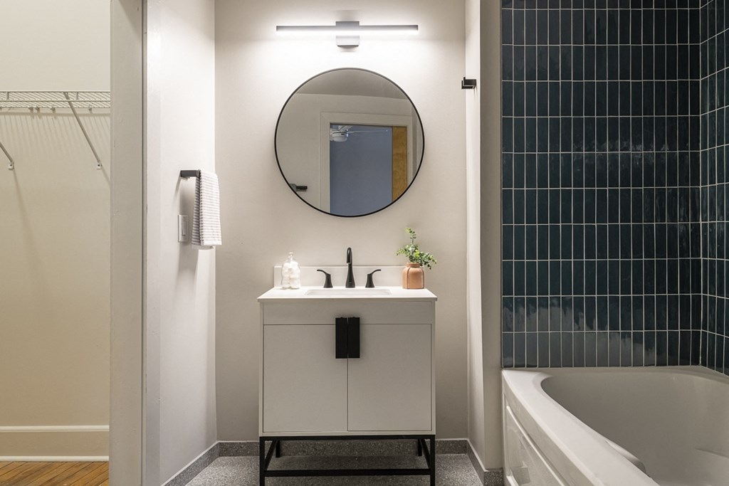 a bathroom with a sink and a mirror and a tub