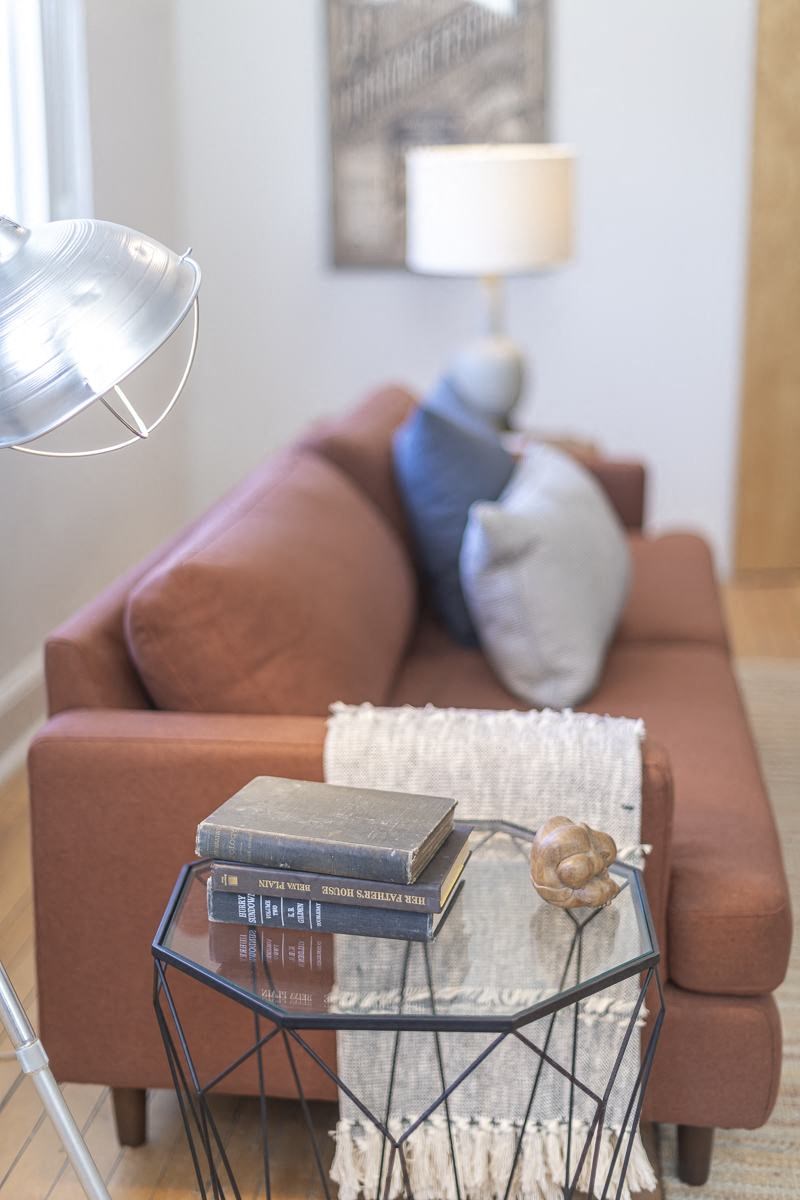 a living room with a brown couch and a glass table