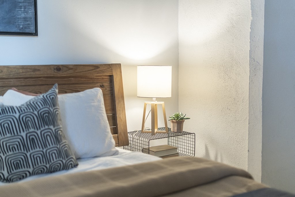 a bedroom with a bed and a nightstand with a lamp