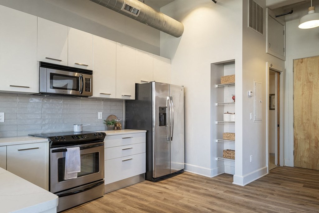 a kitchen with white cabinets and stainless steel appliances